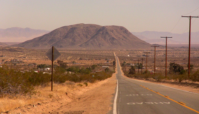 The Integratron is located on flatlands, to the right of the mountain